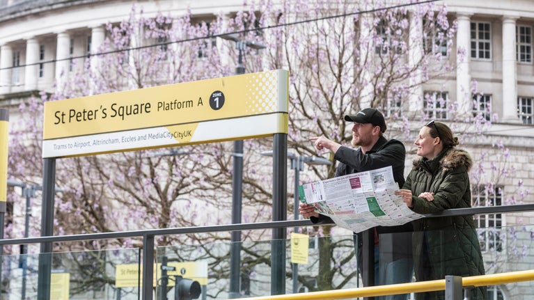 People reading a map at a tube station in St Peter's Square, Manchester, Greater Manchester